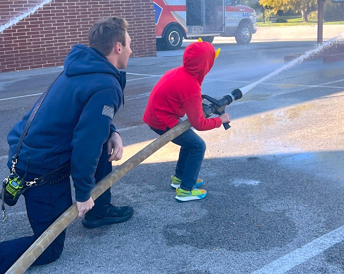 Child holding a fire hose